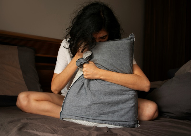 Person holding a pillow, seeking comfort
